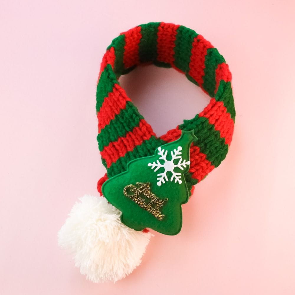Chalina de Navidad para mascotas con diseño de cachorro y gatito tejida en vellón a rayas rojas y verdes, con un encanto festivo con forma de árbol que incluye un copo de nieve y el texto «Feliz Navidad», acentuado con un esponjoso pompón blanco.