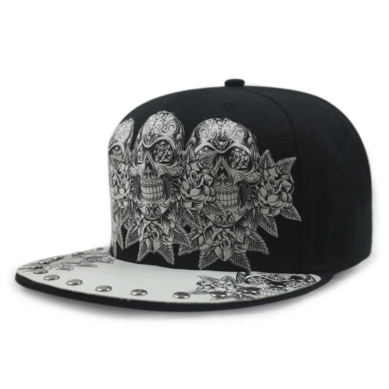 Black sugar skull rivet snapback baseball cap with intricate silver sugar skull and rose embroidery and a white brim accented by metallic studs.