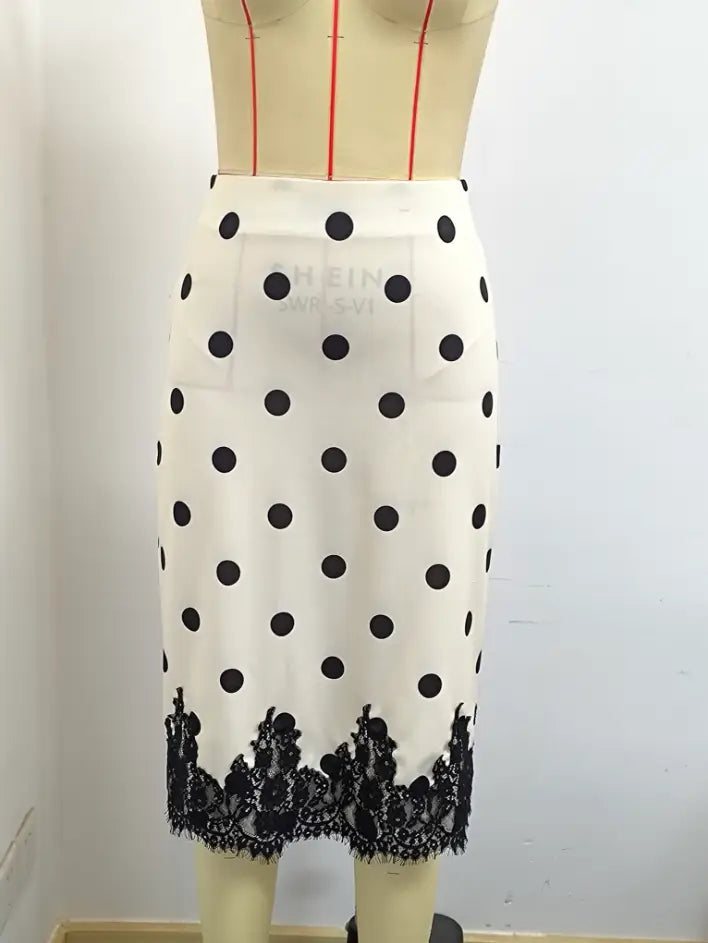 Una falda midi de lunares con encaje en blanco que presenta lunares negros y un ribete de encaje negro en el dobladillo.