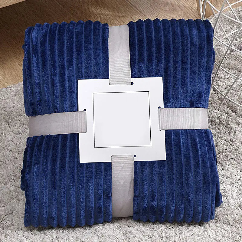 Tiefblaue Fleecedecke 100x150 cm mit plüschiger Struktur und gerippten vertikalen Streifen, ordentlich umwickelt in einem weißen Bändchen-Etikett