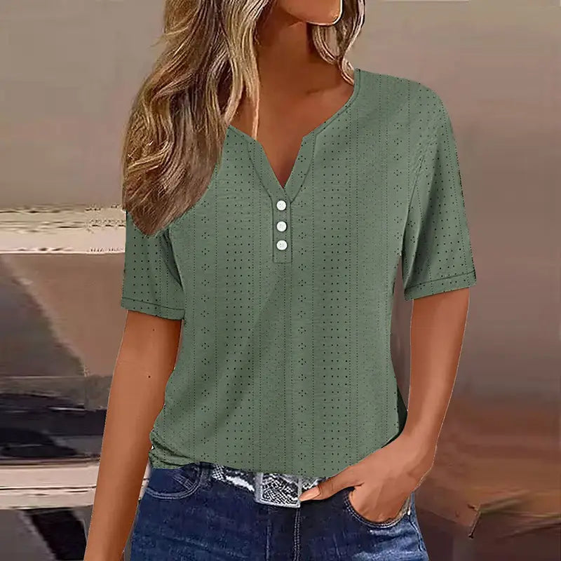 T-shirt boutonné pour femmes à encolure en V et manches courtes, de couleur vert sauge, avec un motif perforé discret et trois boutons blancs alignés sur le devant.