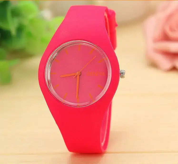 Montre à quartz pour femmes Genève en silicone rose vif, cadran assorti et aiguilles orange, conçue pour un usage vestimentaire décontracté.
