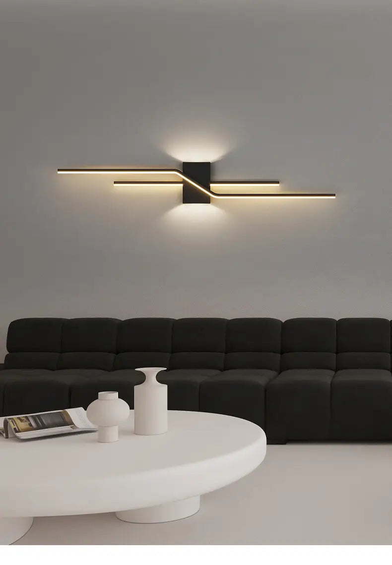 Aplique de pared LED minimalista con diseño lineal moderno en negro y dorado, con barras horizontales entrecruzadas para una iluminación interior contemporánea.