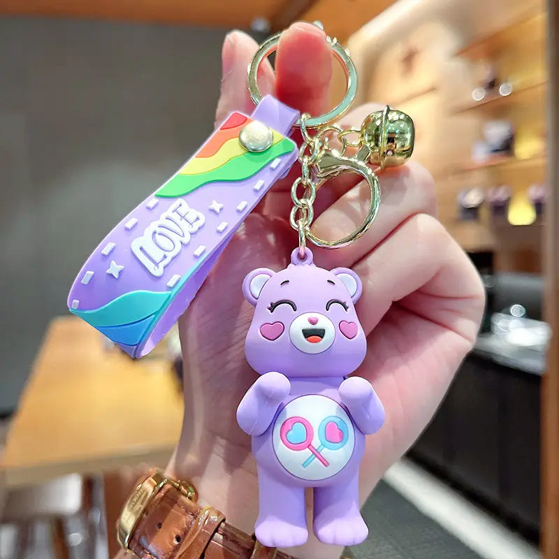 Purple silicone care bears cartoon keychain backpack pendant featuring a candy-themed belly design with a rainbow and love tag.