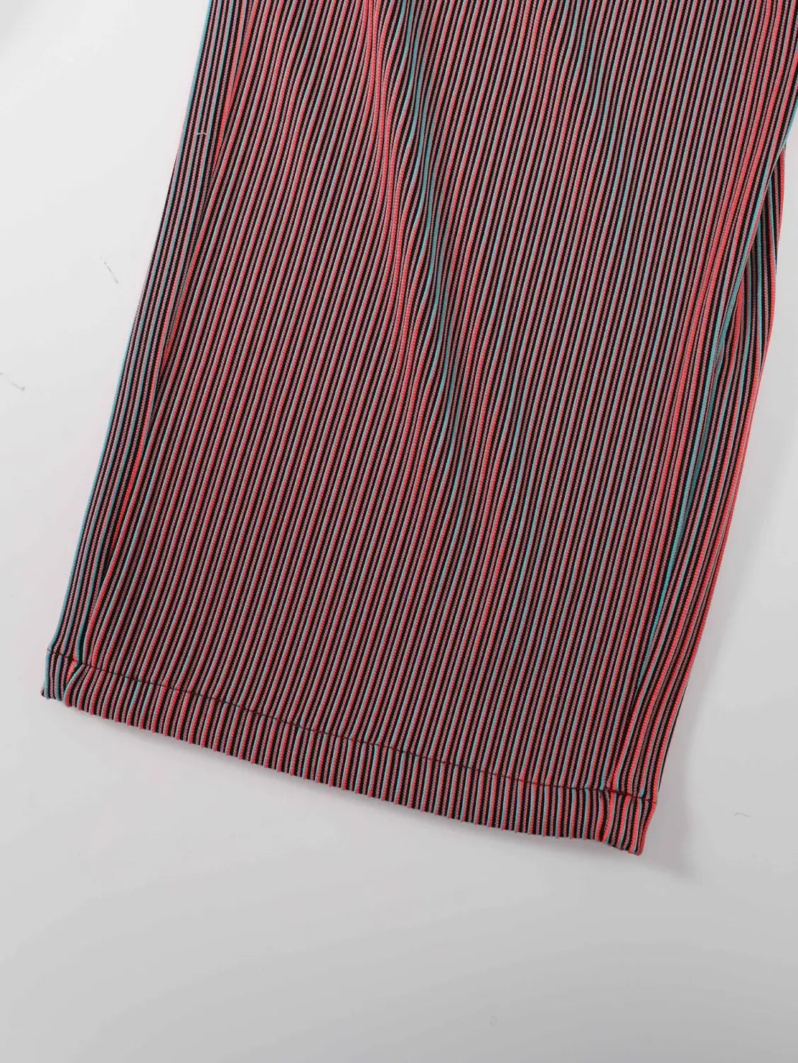 Pantalons décontractés homme style streetwear en velours côtelé avec cordon de serrage, avec rayures rouge et noir, une discrète bande d’accent bleue et un design à plis.