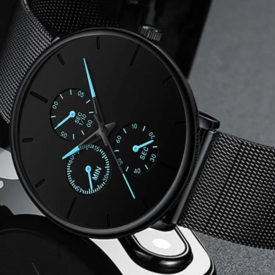 Montre à quartz à maille noire ultrafine pour hommes, avec une sangle en maille et trois sous-cadrans avec des aiguilles bleu lumineux.