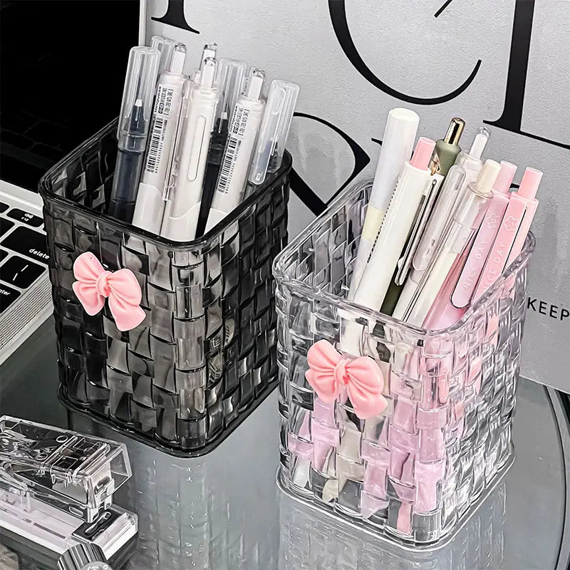 bow pen holder desktop storage organizer featuring clear and black woven plastic pen holders adorned with pink bows.