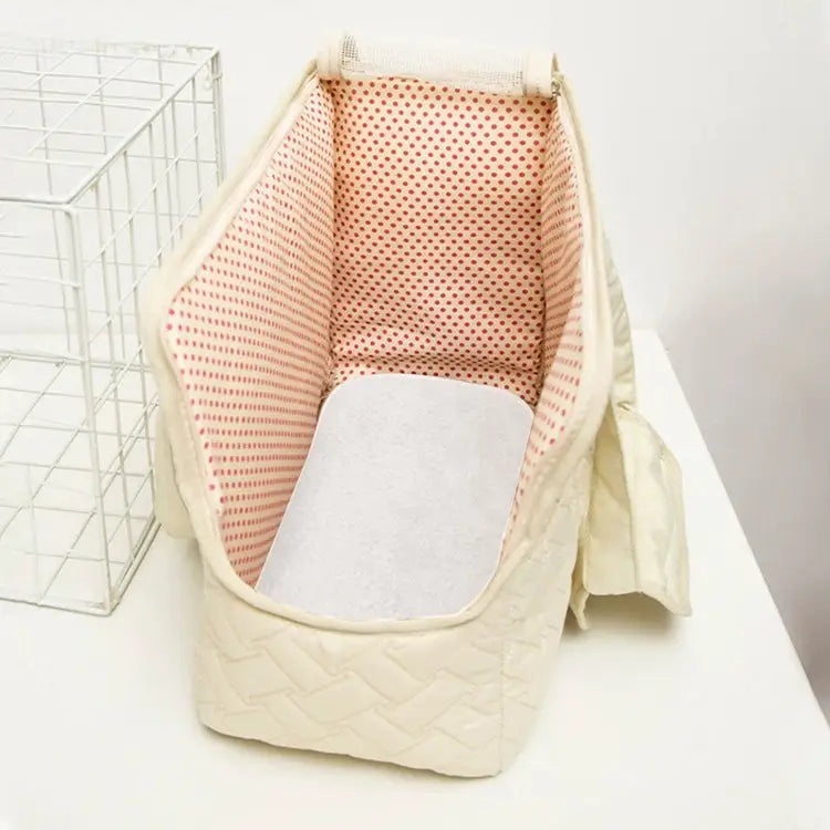 Sac pour bébé couffin en tissu matelassé de couleur crème, avec doublure intérieure à pois roses et un coussin blanc absorbant, pour une utilisation respirante comme petit porte-chien.