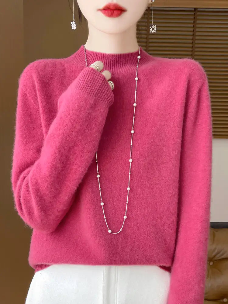A soft vibrant pink merino wool pullover sweater for women with a high neckline and long sleeves.