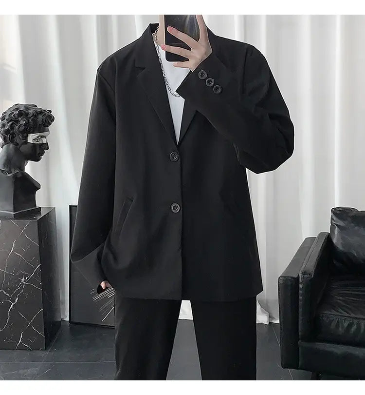 Schwarzer übergroßer Herren-Casual-Loose-Blazer in einfarbigem Design mit Dreiknopf-Vorderseite und dezentem Texturdetail.