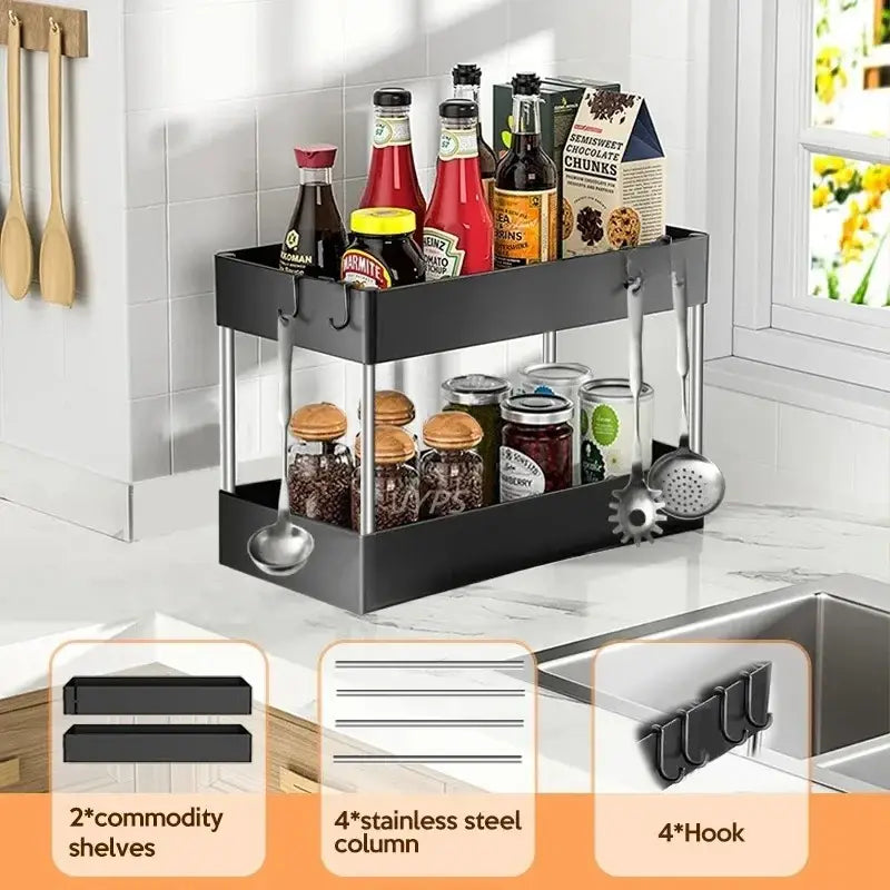 Organizador negro de almacenamiento bajo el fregadero, de dos niveles, con columnas y ganchos de acero inoxidable, diseñado como una estantería multifuncional tipo cajón por niveles para uso en la cocina.