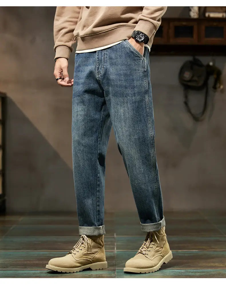 Men loose denim harem jeans in medium-wash blue denim with rolled cuffs and a relaxed fit.