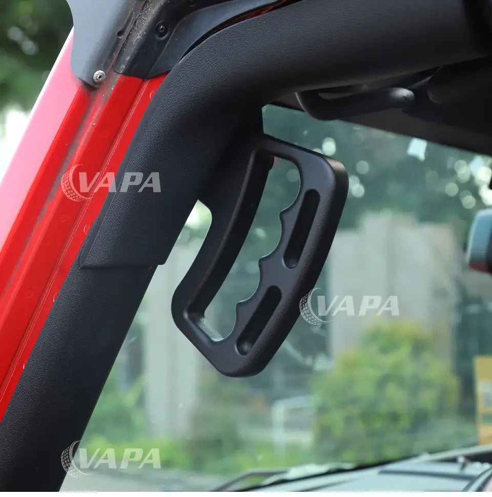 Schwarzer Kunststoff-Greifgriff mit strukturierter ergonomischer Gestaltung, montiert am roten Jeep Wrangler JK-Rahmen.