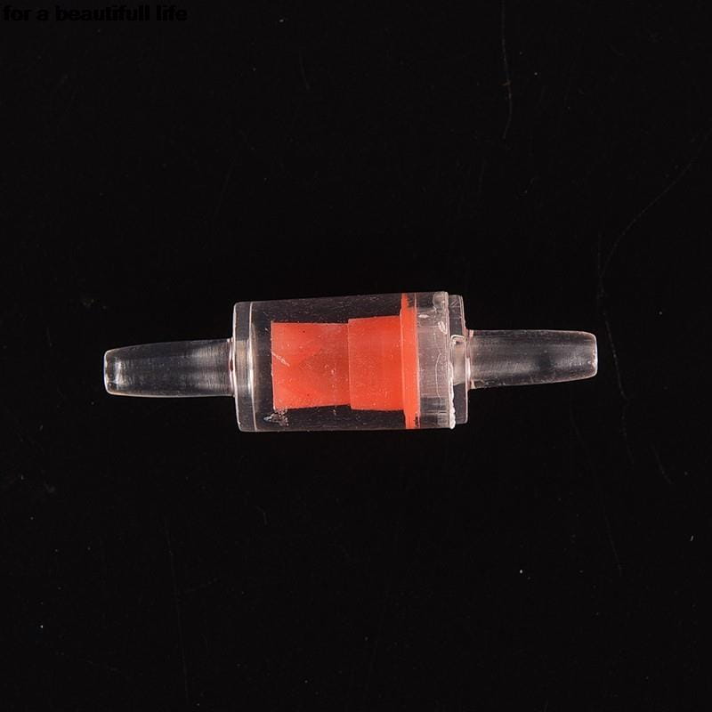 Válvula de retención de plástico transparente para bomba de aire de acuario con un componente interno naranja brillante para el control del flujo de aire unidireccional.