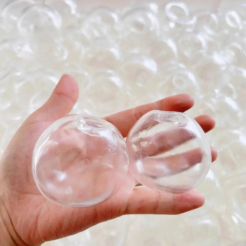 Une main tenant des sphères en plastique transparent translucide pour un jouet antistress sensoriel fait main en forme de balle molle.