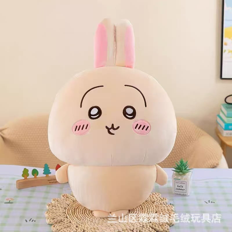 Alegre conejito de peluche beige chiikawa, con orejas interiores rosadas, mejillas rosadas y ojos sencillos bordados en negro; animal de peluche suave.