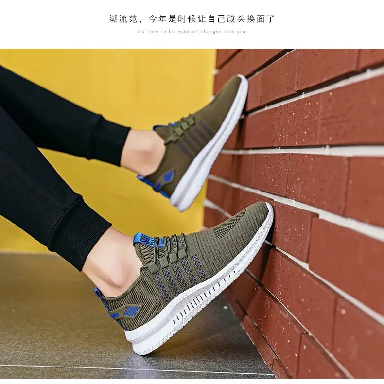 Herren-Atmungsaktive legere Strick-Sneaker aus Olivgrünem Mesh mit weißen Sohlen und blauen Akzenten an den Schnürsenkeln sowie an der Fersenlasche.