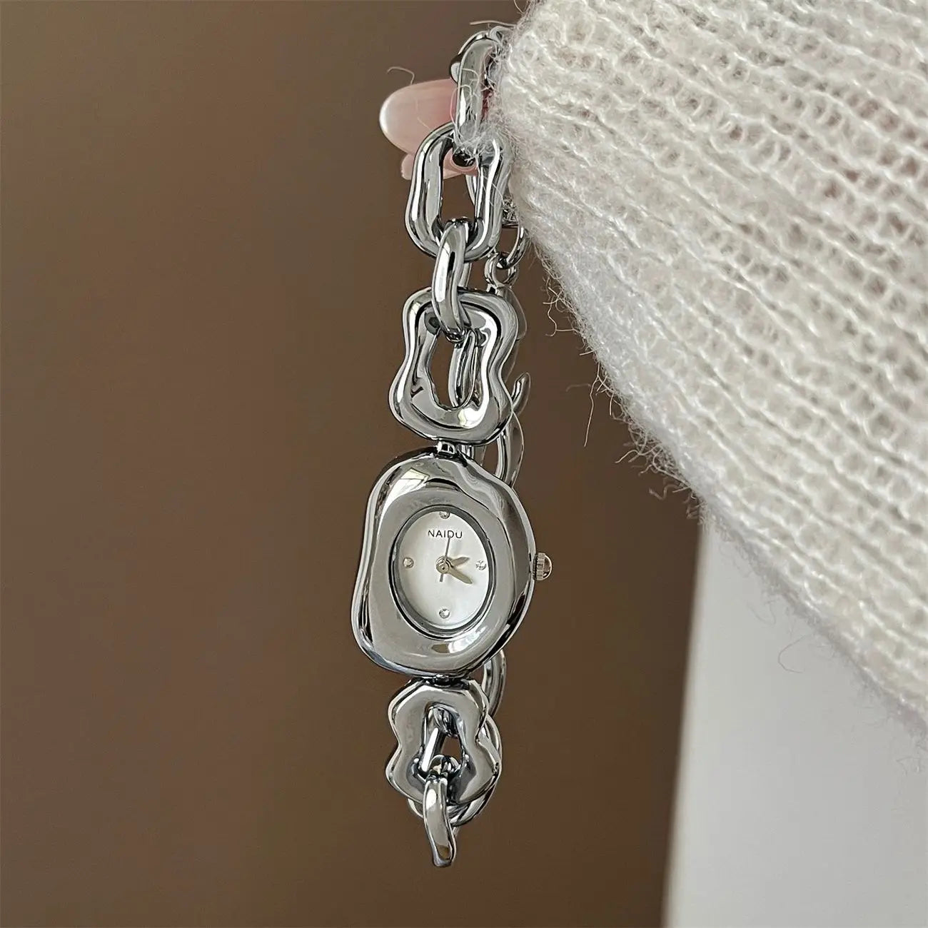Silver-toned naiqu wristwatch with sleek irregularly shaped case and bold chain link bracelet in gold chain link vintage design.