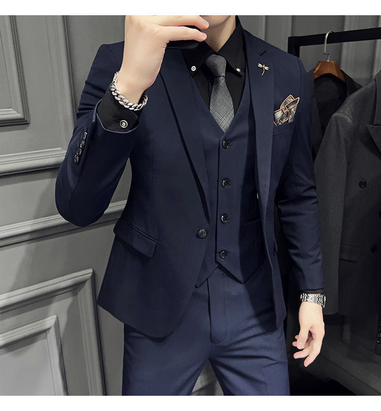 Ensemble de costume trois pièces slim fit pour homme bleu marine, avec texture discrète et coupe sur mesure, comprenant 9 pantalons courts à la cheville et un type de fermeture par boutons.