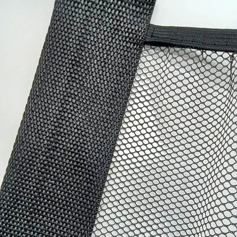 Schwarze Einkaufstasche aus Netzgewebe mit gewebtem Griff, vorgesehen als elastisches Netz für die Kofferraumorganisation.