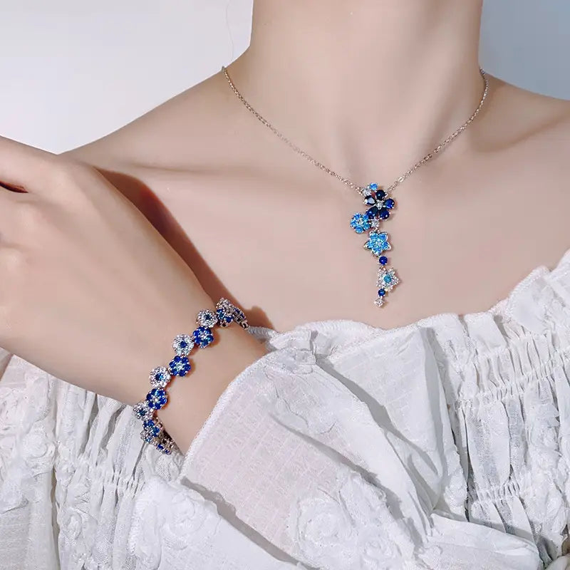 優雅なブルーの花柄シルバー花ジルコンのネックレスおよびブレスレットセット。きらめくクリスタルのアクセントと、精巧な星形デザインを施しています。