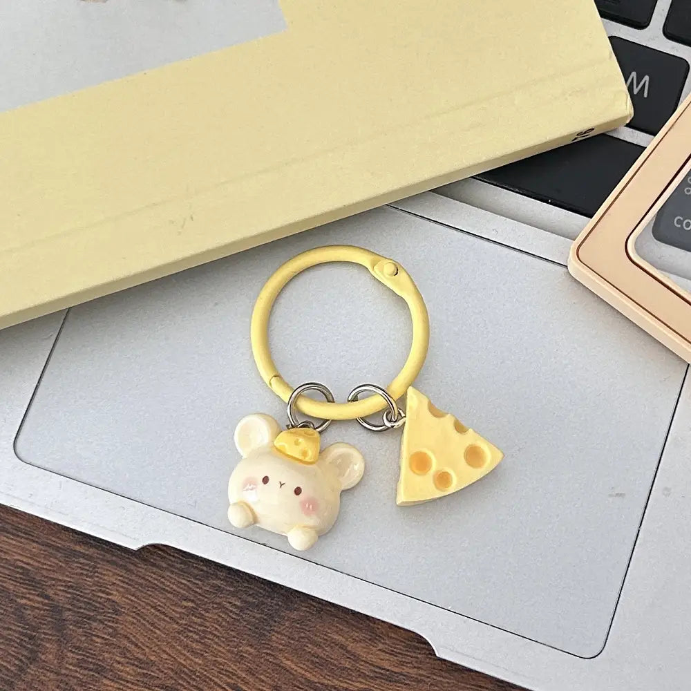 Yellow silicone cheese mouse cartoon keychain featuring a cream-colored mouse charm wearing a cheese slice hat and a matching triangular cheese wedge pendant for kawaii bag charm use.