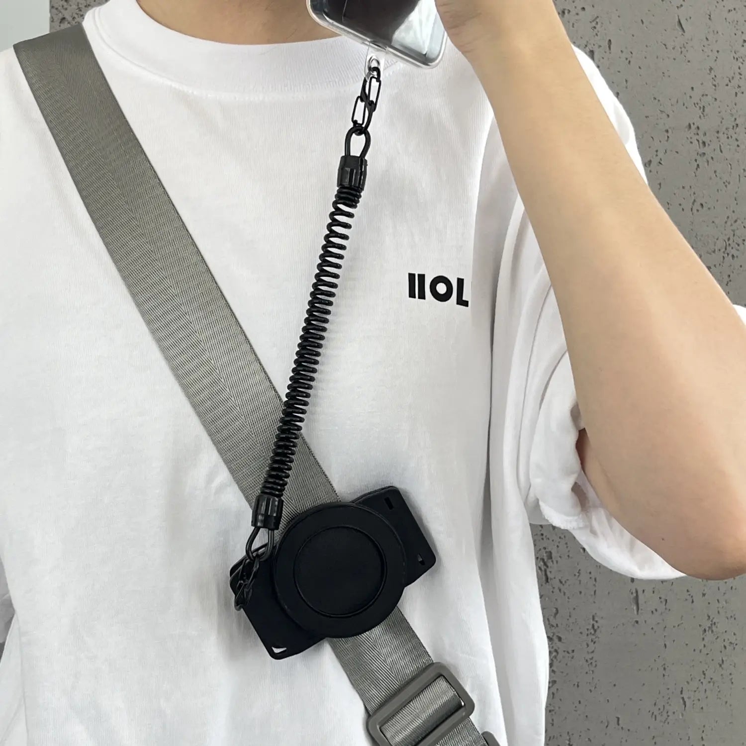 Schwarzer gewellter Telefonriemen mit verstellbarem grauem Schultergurt und schwarzem Kunststoffverschluss, dargestellt von der Rückseite für die magnetische Telefon-Rucksackclip Universalhalterung