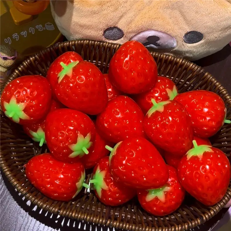 Jouet sensoriel de type balle anti-stress en forme d’arachide, en forme de fraises en plastique rouges brillantes aux couleurs vives, avec des sommets verts feuillus.