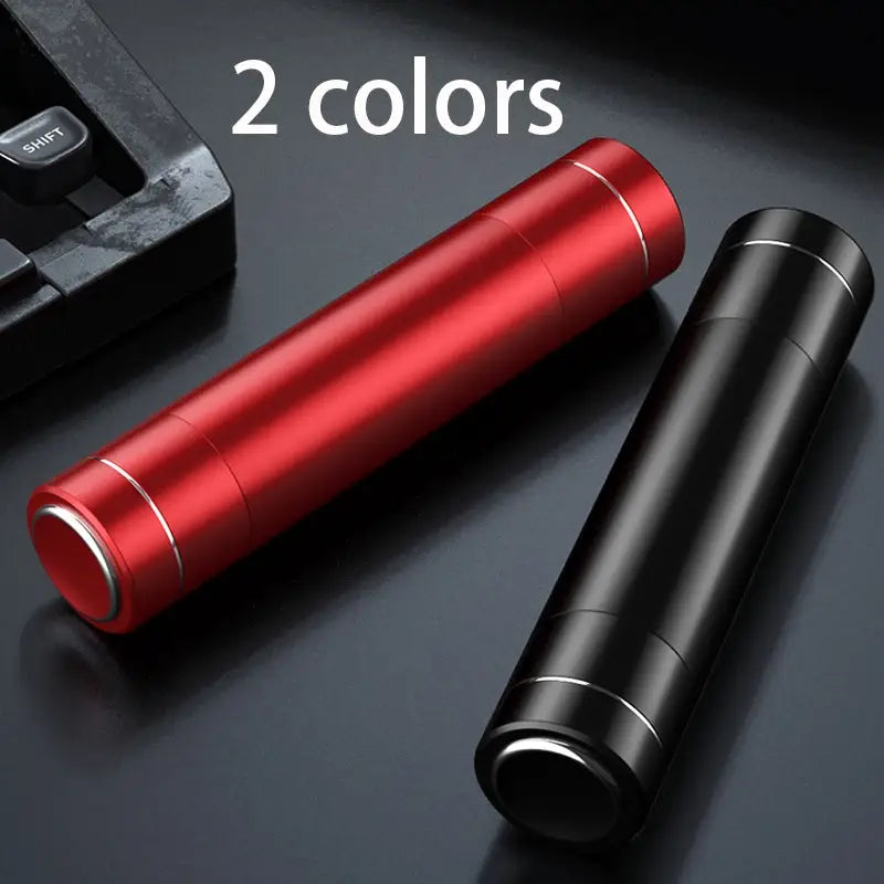 Tazas de viaje cilíndricas metálicas rojas y negras con ribete plateado, mostradas junto con una herramienta de martillo de emergencia para automóvil y rompecristales con cortador del cinturón de seguridad.