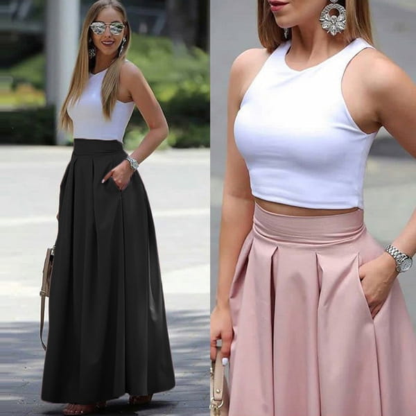 white sleeveless crop top with a high neckline and fitted silhouette paired with a pleated high waist maxi skirt