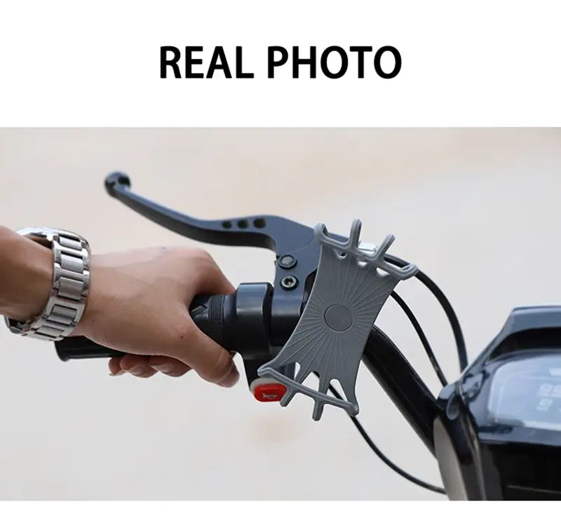 Soporte universal para teléfono de bicicleta de silicona gris con un diseño tipo estallido solar acoplado al manillar de una motocicleta