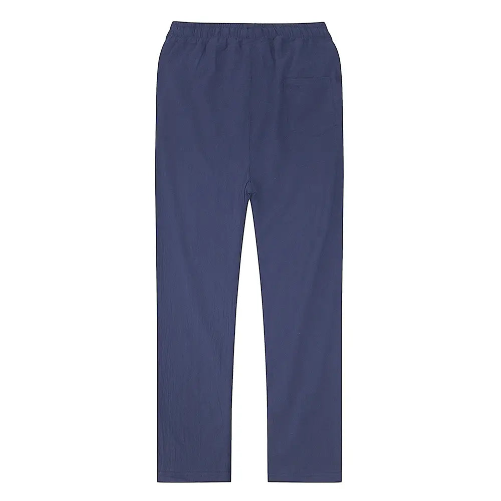 Men cotton linen trousers in navy blue with an elastic waist, subtle texture, and a single side pocket designed for breathable casual wear.