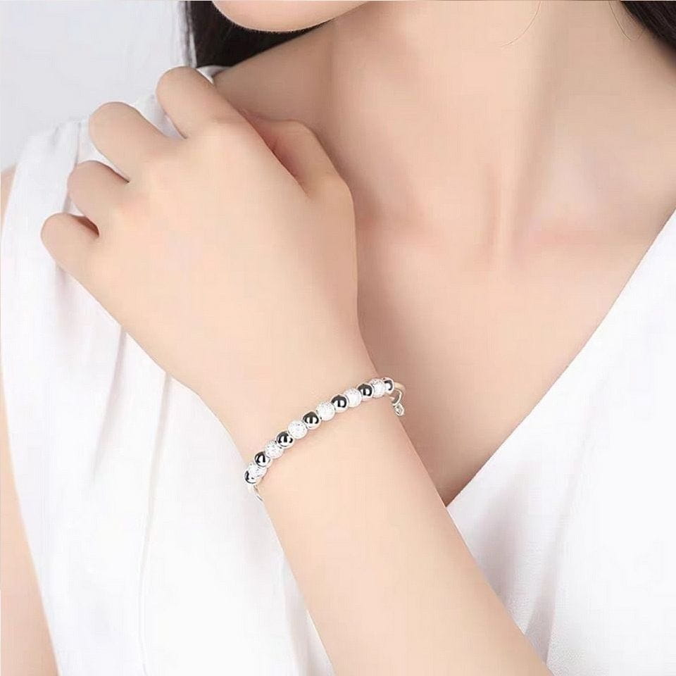 Silver beaded bangle bracelet for women featuring black beads and a delicate clasp with adjustable sizing.