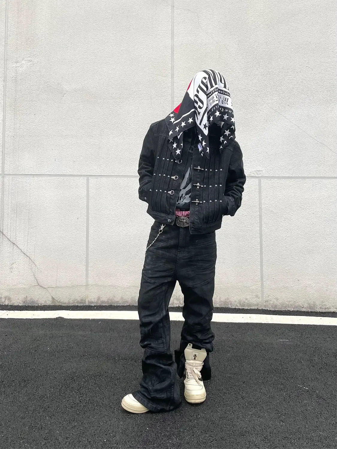 Les jeans empilés en denim noir Y2k vintage pour hommes associés à une veste en denim noire comportant des clous argentés et une capuche à motif d’étoiles.