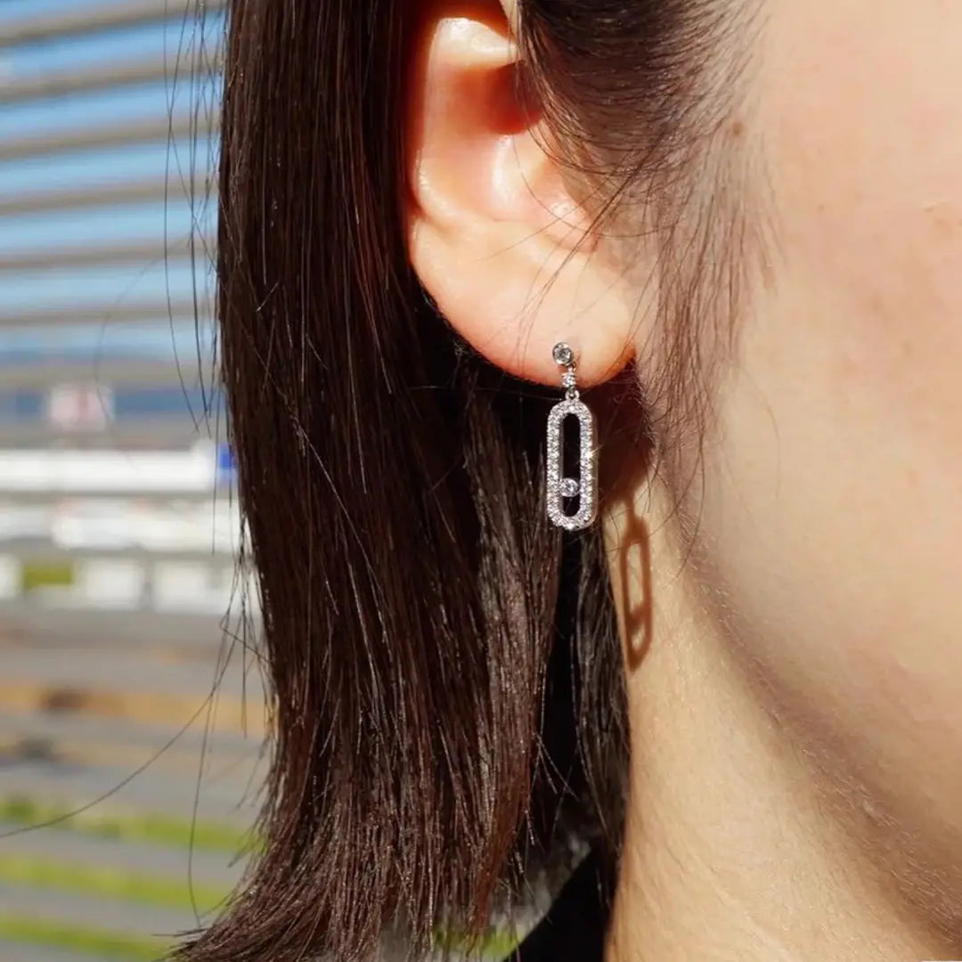 Boucles d’oreilles pendantes rectangulaires en argent et diamants, avec des gouttes ovales plaquées argent, un sertissage pavé de diamants et une pierre d’accent centrale.