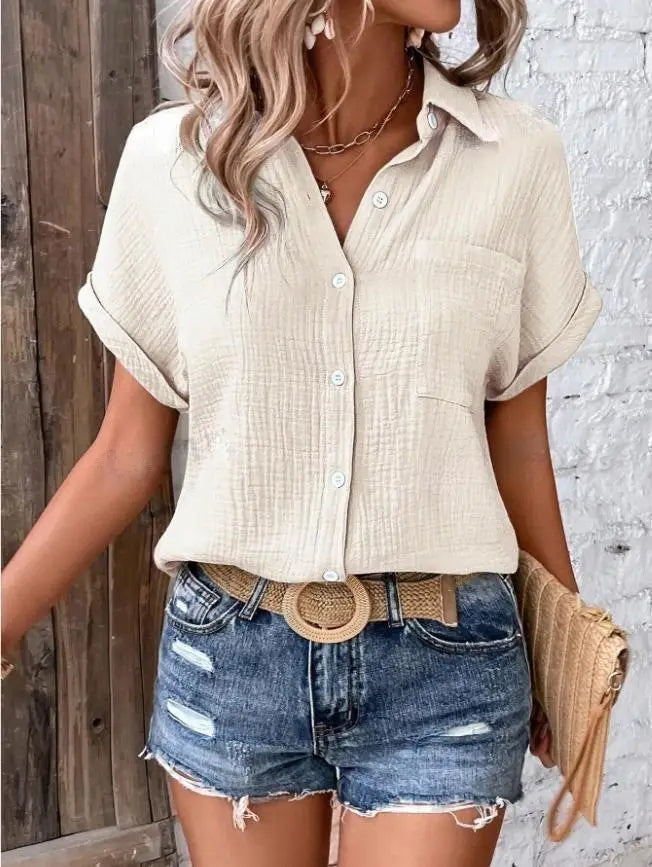 Beige textured cotton women short sleeve button up shirt with rolled sleeves and a chest pocket.