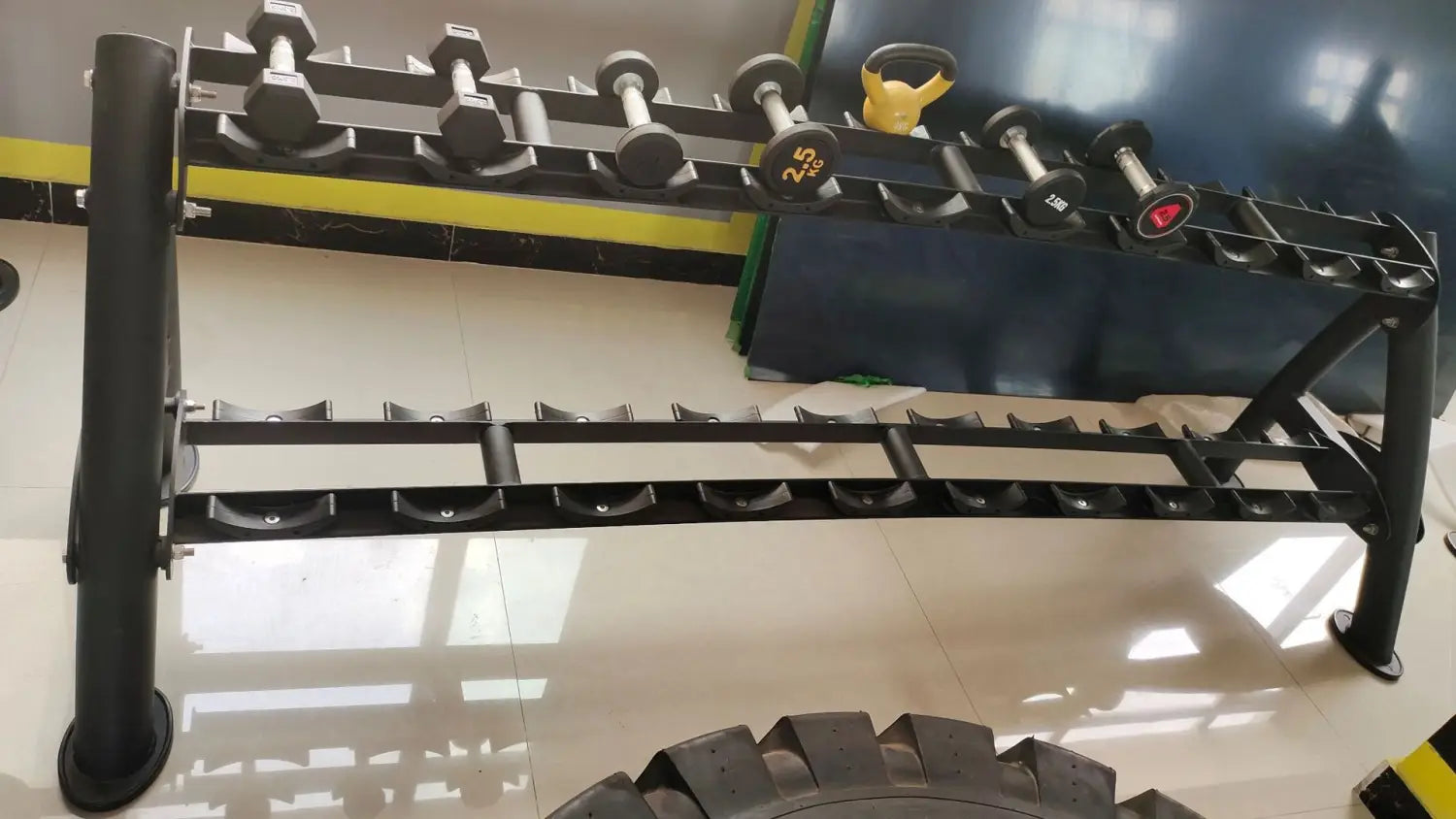Black metal commercial 2-tier dumbbell rack holding various weights for gym organization and storage.