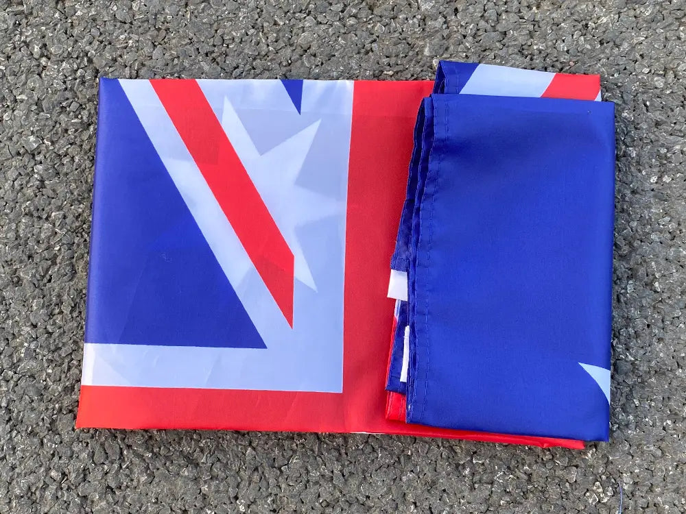 Una bandera nacional australiana australiana de 90x150 cm doblada, que muestra colores rojo, blanco y azul sobre una superficie de tela