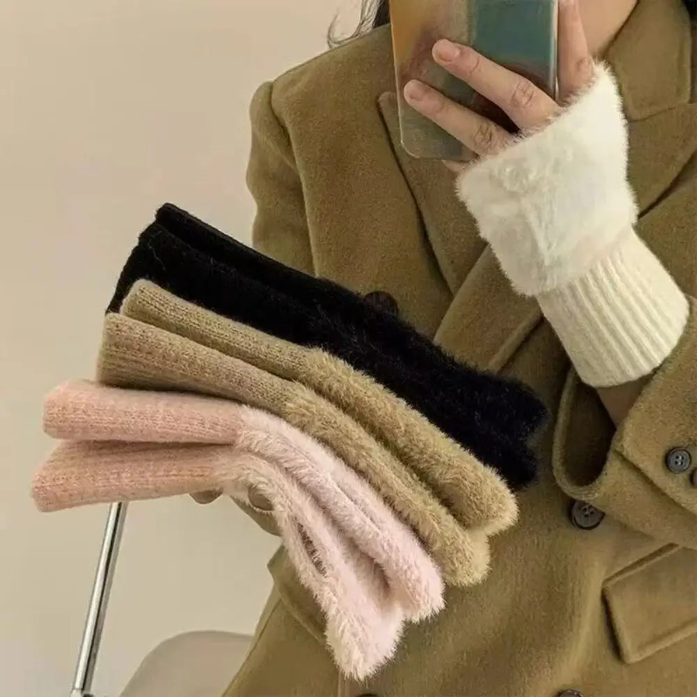 A stack of fluffy fingerless knit gloves cream featuring cozy plush fur in soft pastel and neutral tones.