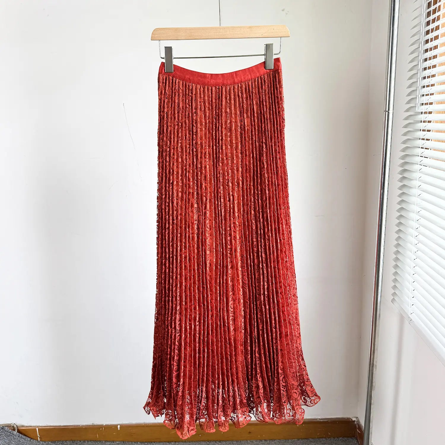 A vibrant red high waist pleated midi skirt made of velvet with lace trim at the hem, suitable for Y2k streetwear.
