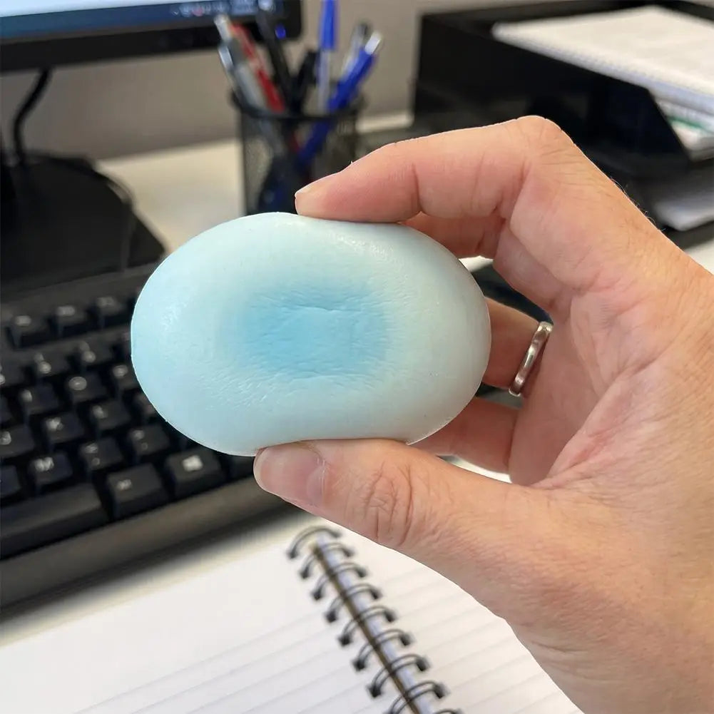 Un pastel de queso esponjoso y blando ovalado y suave de color azul claro, lento en elevarse, con un centro azul ligeramente más oscuro, diseñado para aliviar el estrés.