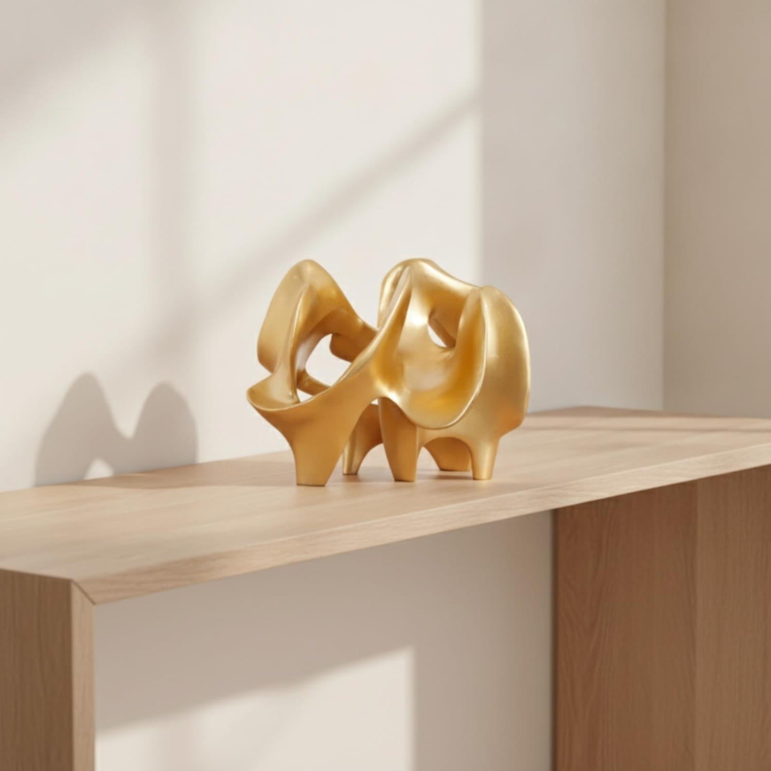 resin decorative item featuring a golden abstract sculpture with smooth flowing curves and a polished metallic finish