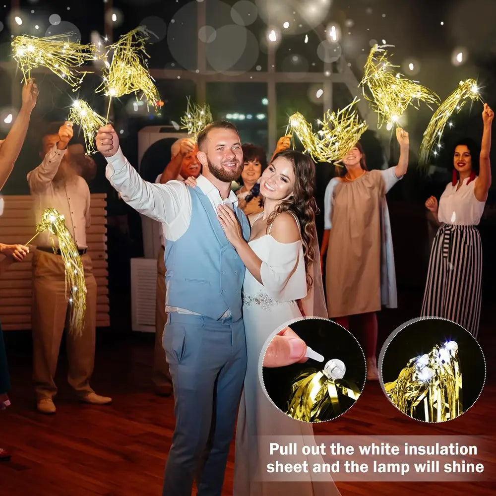 Bâtons lumineux de mariage à LED avec des rubans en tinsel doré, dotés de lumières de type étincelles scintillantes, et d’une feuille d’isolation blanche qui brille lorsqu’elle est sortie.