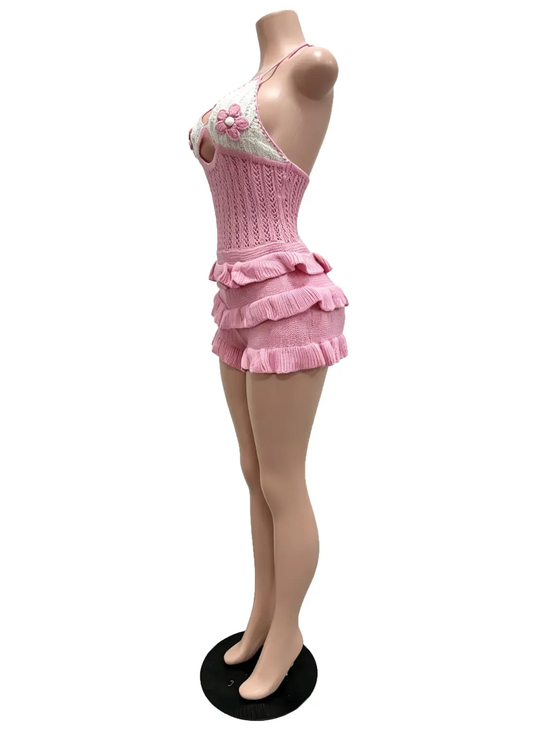 Pink knitted ruffle halter romper summer playsuit featuring a knitted halter top with ruffled shorts and a floral embellishment.
