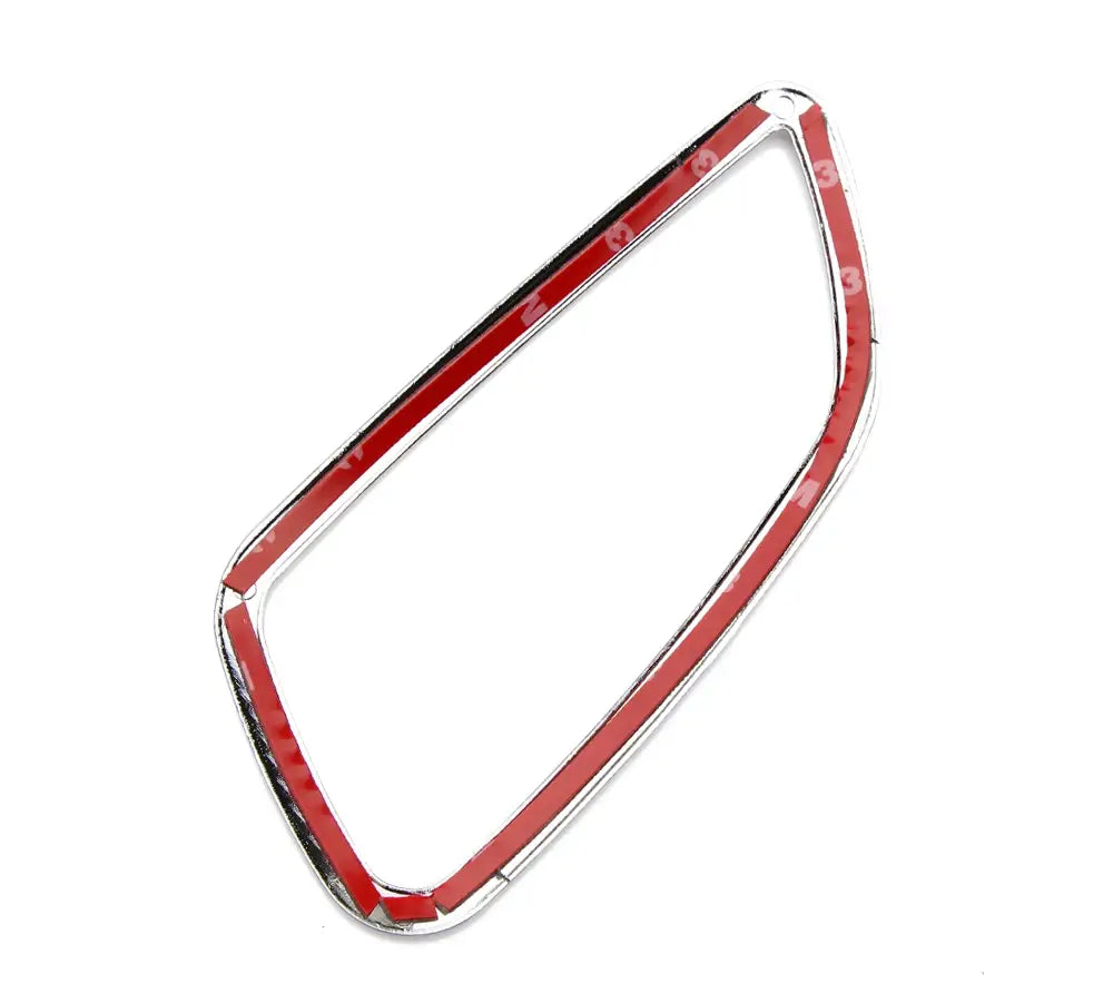 Moldura de manija interior de la puerta con acabado en cromo para Chevrolet Cruze 2009-2014, que muestra el adhesivo rojo de respaldo con la forma adecuada para ajustarse alrededor de una rejilla de ventilación del vehículo.