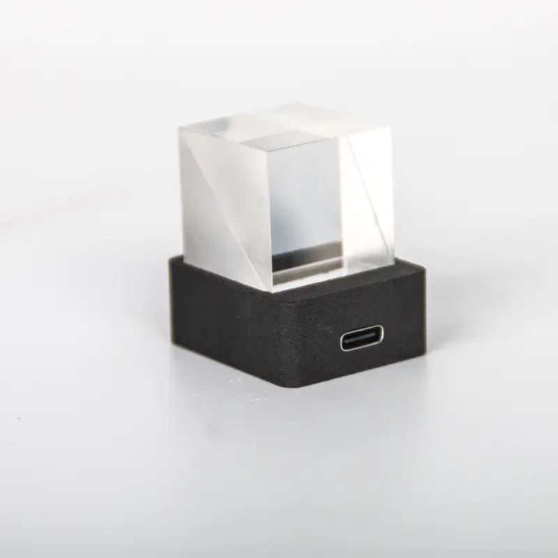 Clear acrylic cube smart weather station crystal gif clock mounted on a black rectangular base with usb-c port.