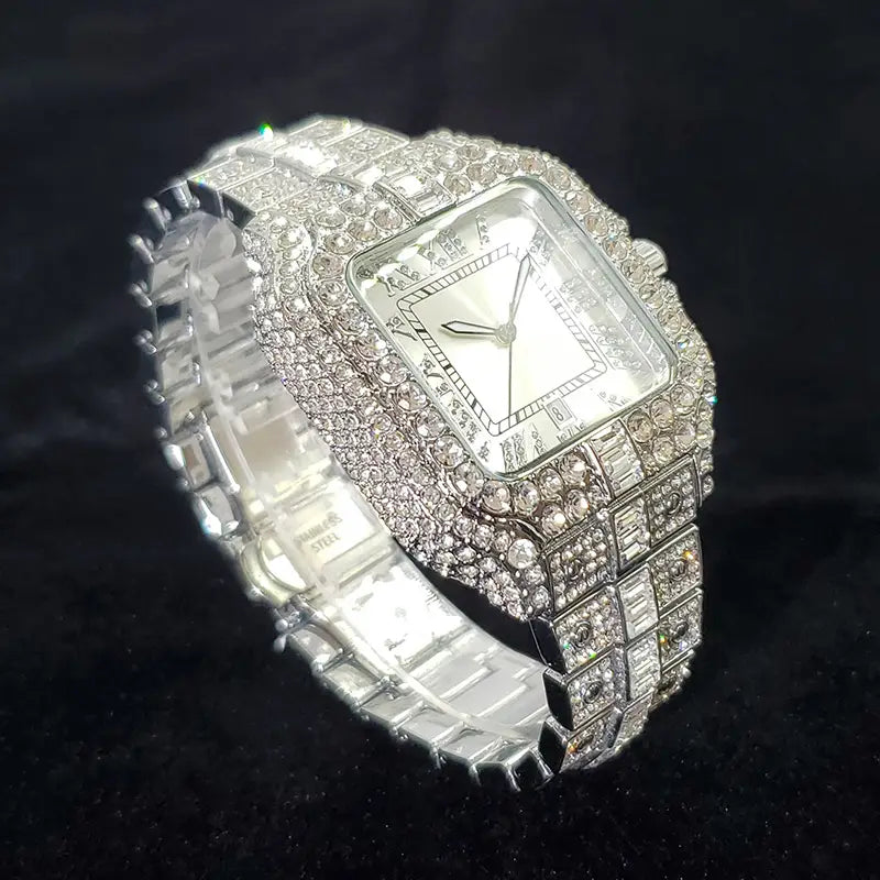 A dazzling iced out diamond square watch for men in silver with a blue tint featuring a square face and an intricate band encrusted with sparkling clear crystals.