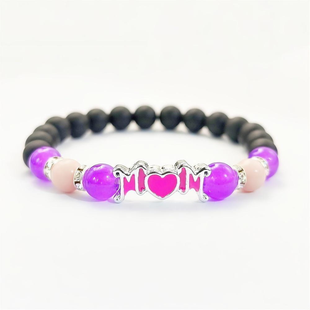 Pulsera para madre con brillo en la oscuridad de cuentas moradas y negras, con un dije plateado para mamá con un corazón rosa en el centro, ideal como joyería de regalo para mamá.