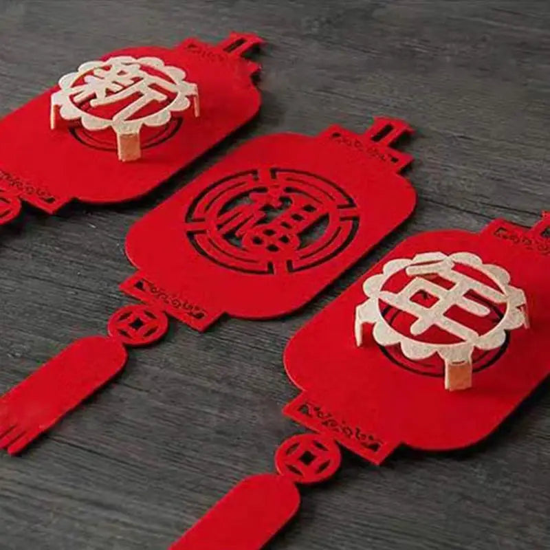 Rote Papierlaternen-Anhängerdeko mit filigranen chinesischen Schriftzeichen und dekorativen Ausschnitten für die Mondneujahr-Dekoration zum Chinesischen Neujahr.