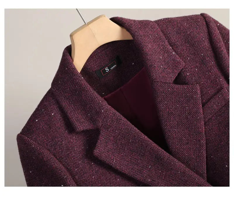 A maroon wool blend double breasted blazer with textured fabric, subtle glittery specks, and a structured collar.